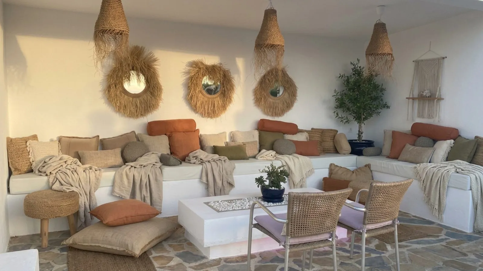 Covered terrace lounge in Jávea styled with handmade cushions, bolsters and throws in natural tones