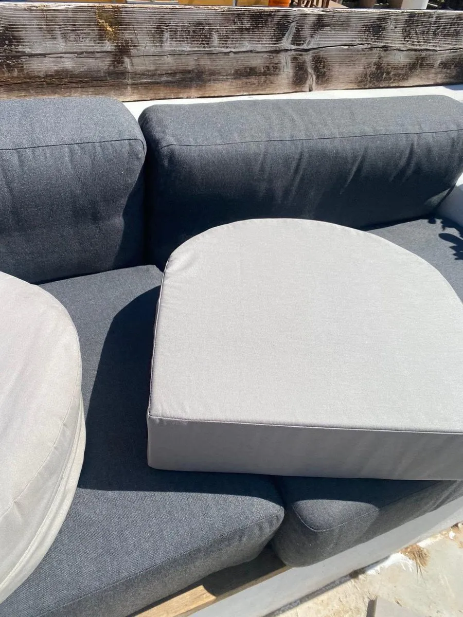 Made-to-measure shaped seat cushion in weatherproof grey fabric on an outdoor sofa