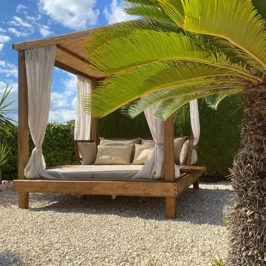 Outdoor daybed with handmade cushions under a canopy in Jávea