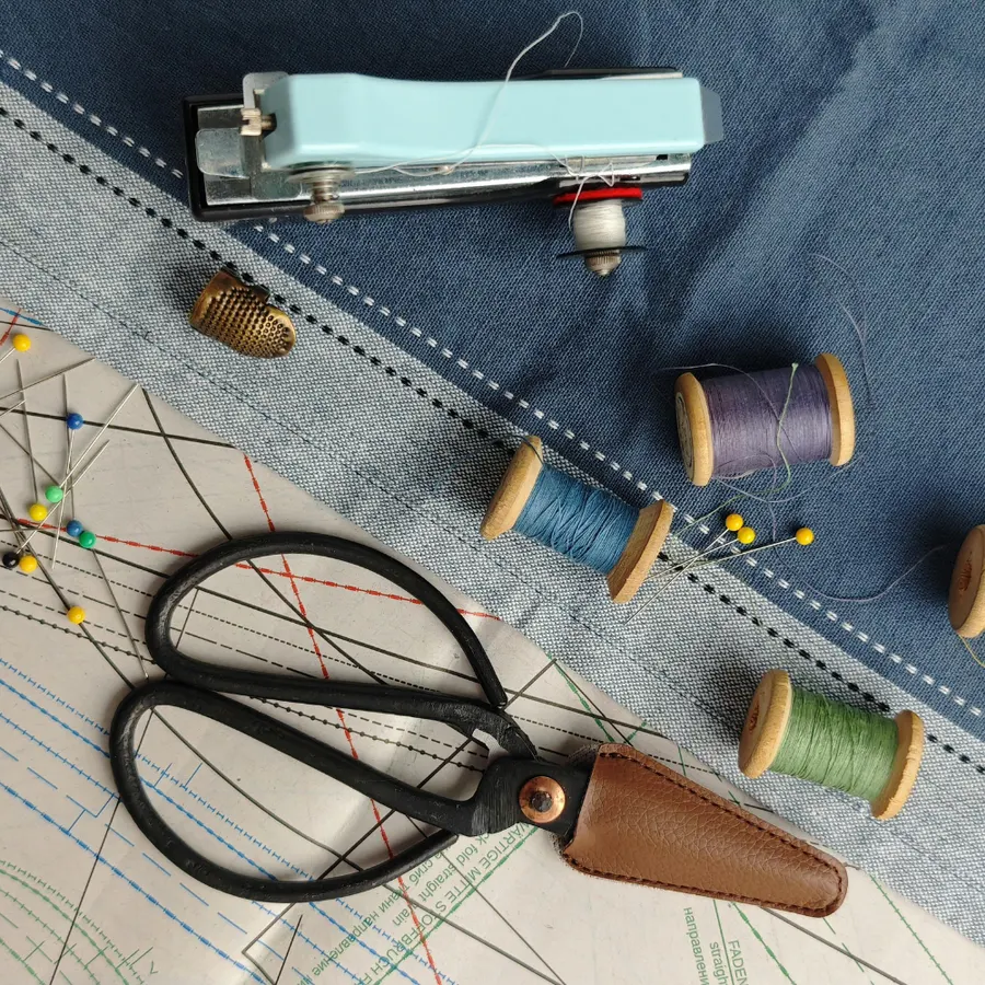 Sewing scissors, thread spools, thimble and pattern on Cindy's worktable